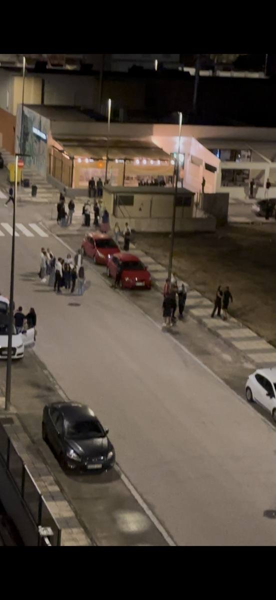 Personas en calzada de Playa Oliva Terranova de madrugada tras cierre de local de ocio
