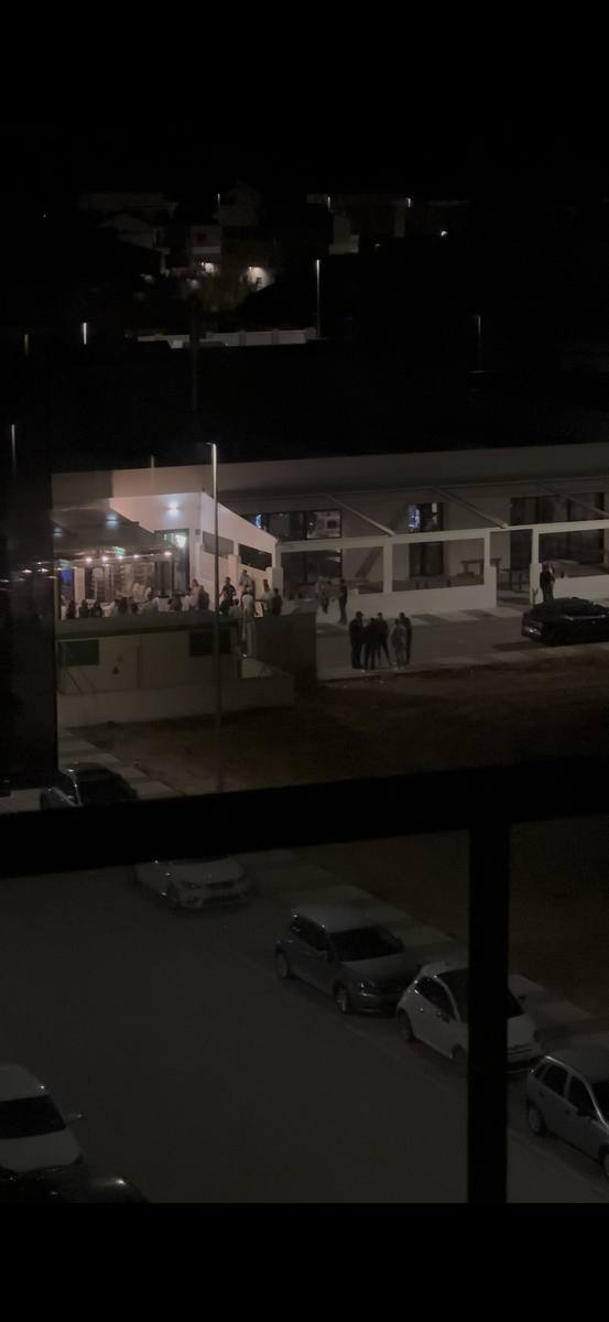 Aglomeración nocturna en calle de Playa Oliva Terranova vista desde ventana residencial