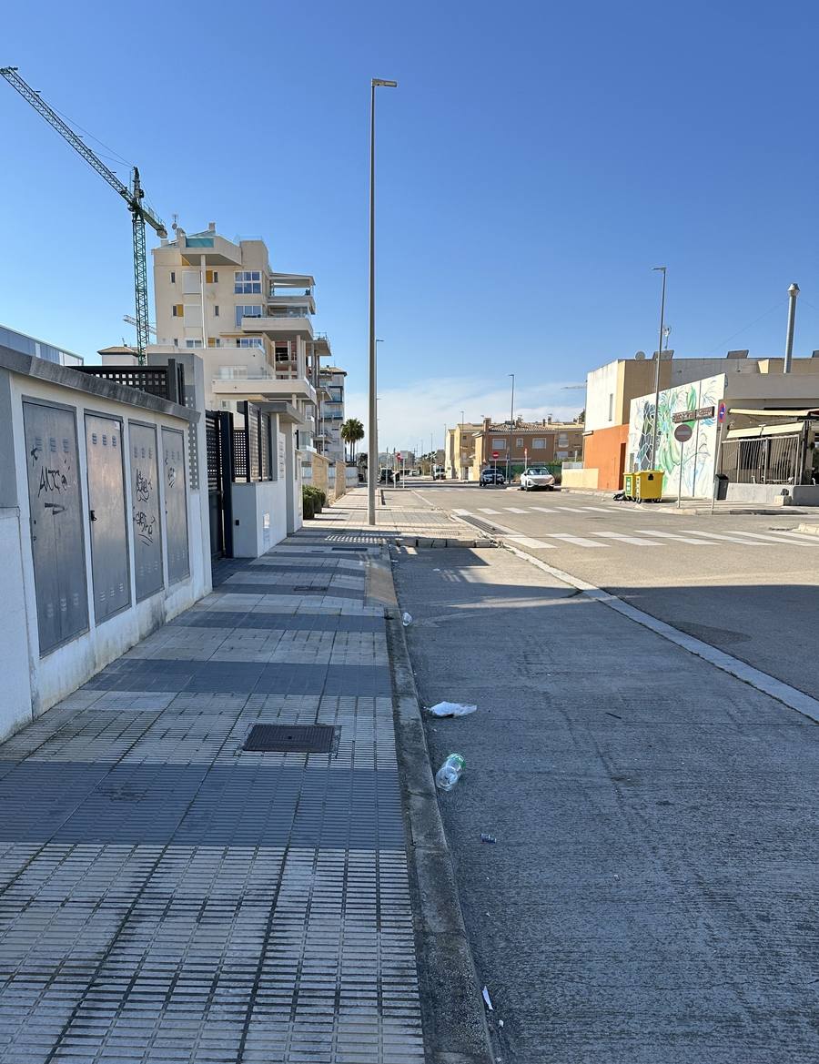 Valla metálica deteriorada con grafitis en acceso a urbanización Playa Oliva