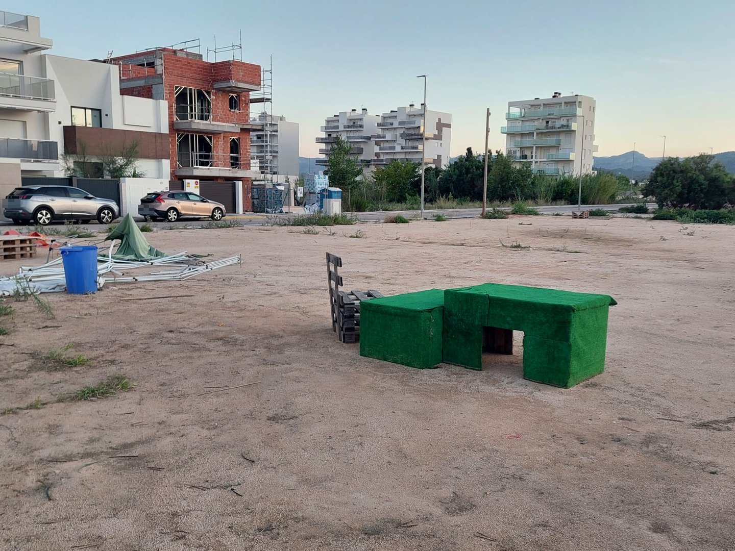 Estructuras desmontadas, palés y elementos revestidos de césped artificial.